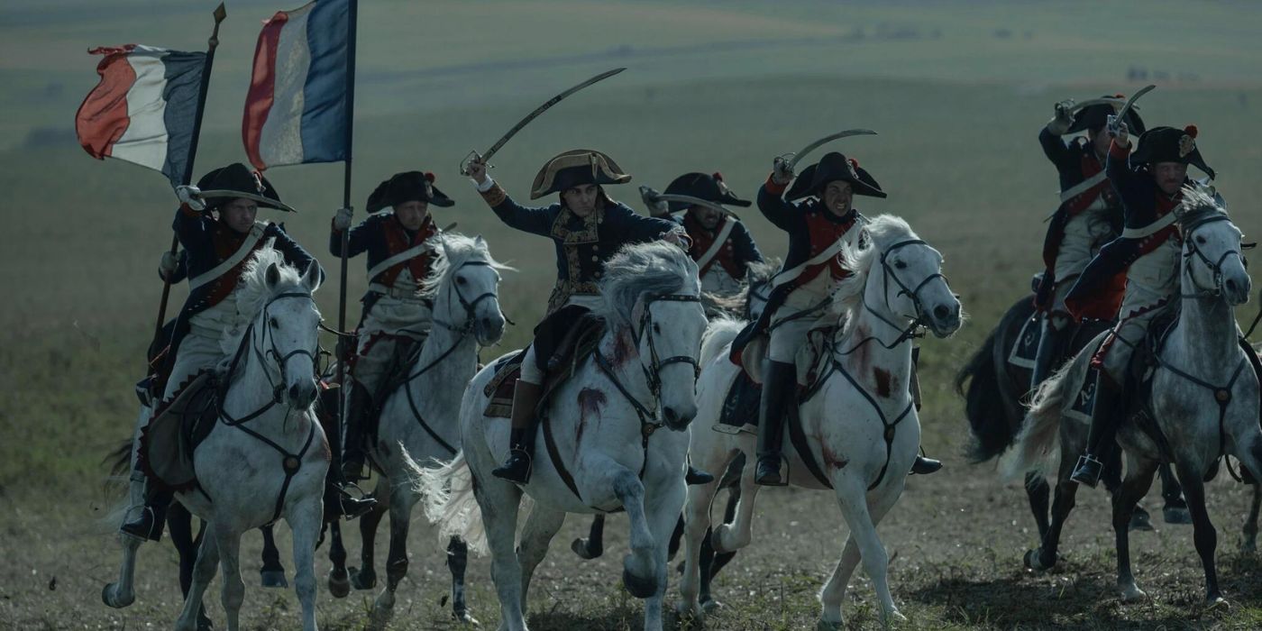 Joaquin Phoenix as Napoleon Bonaparte leading an army on horseback in Ridley Scott's Napoleon
