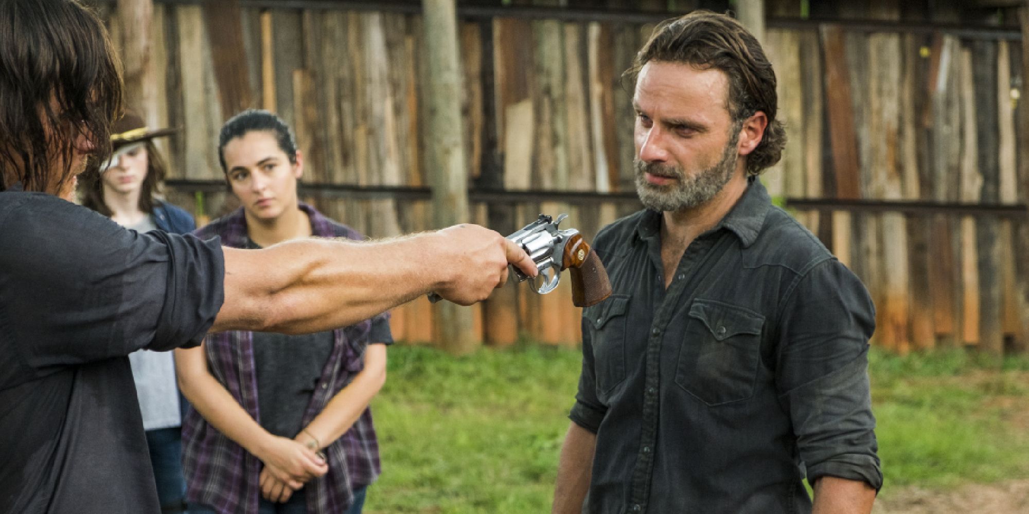 Norman Reedus handing Andrew Lincoln a gun in The Walking Dead