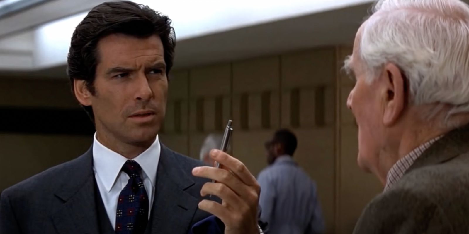 James Bond discuss an explosive pen bomb gadget with Q in the film GoldenEye.