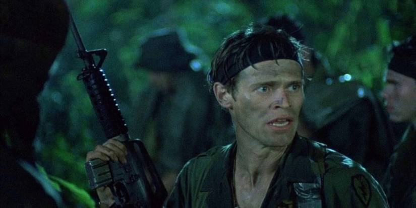 Sgt. Eliass turēja pistoli un skatās pa kreisi džungļos Bēdā (1986)
