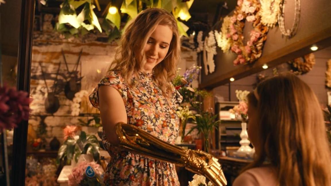 Rachel Brosnahan in The Golden Arm, showing the arm to a little girl. 