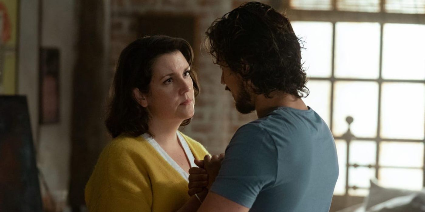 Adam, played by Peter Gadiot, holds Shauna's, played by Melanie Lynskey, hands in Yellowjackets.