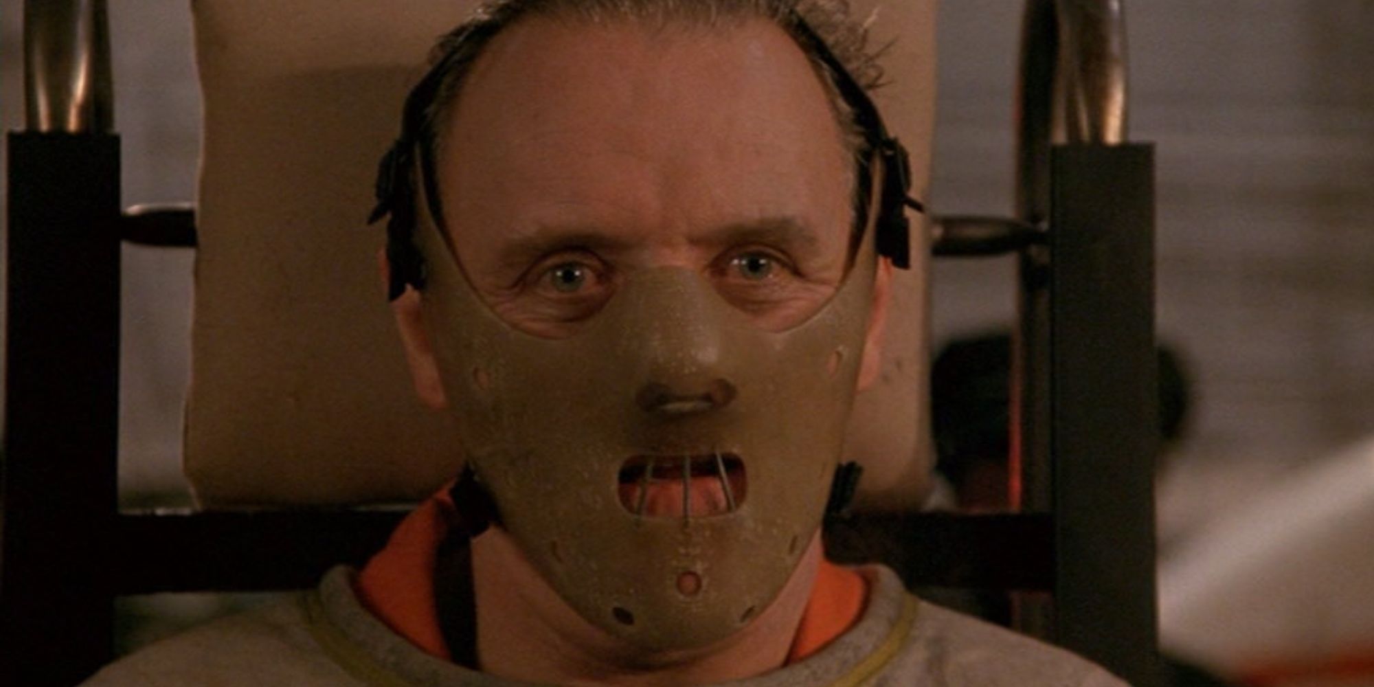 Hannibal Lecter strapped to a gurney and wearing an anti-bite mask