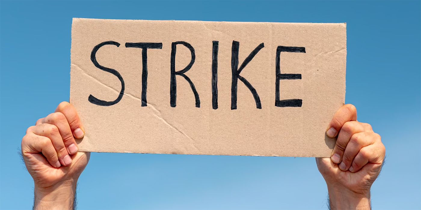 Stock photo of a person holding a sign that says Strike