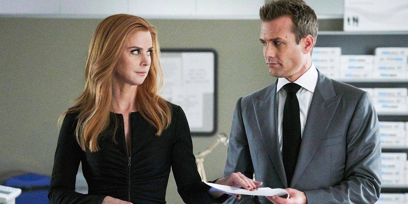 Donna hands Harvey a piece of paper in a scene from Suits.