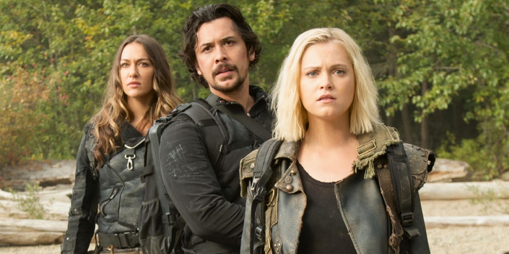 Clarke Griffin looks forward while Bellamy Blake and Echo stand behind her in the CW series, The 100.