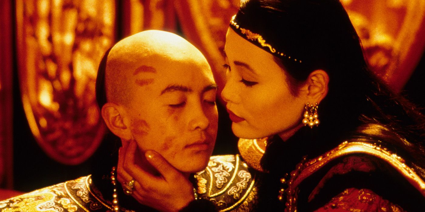 A woman embracing a young boy who has his eyes closed and lipstick kiss marks all over his face in The Last Emperor.