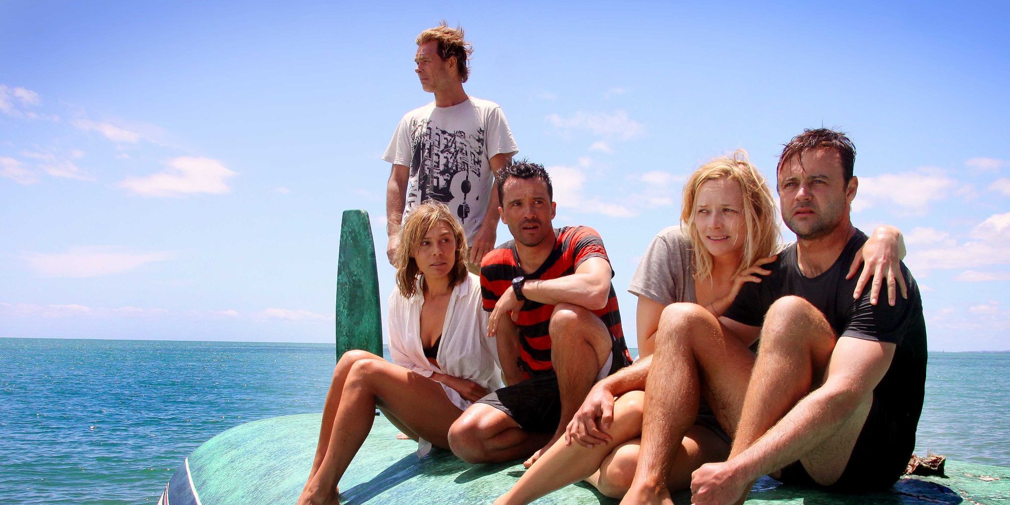 Luke (Damian Walshe-Howling) and his friends sit on a boat in The Reef (2010)