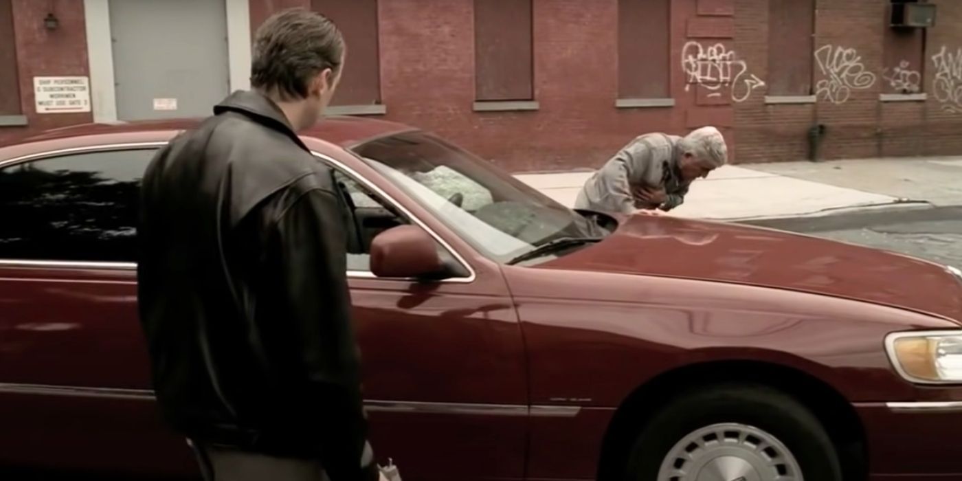 Steve Buscemi standing on one side of a car watching Frank Vincent stumbling on the other side in The Sopranos