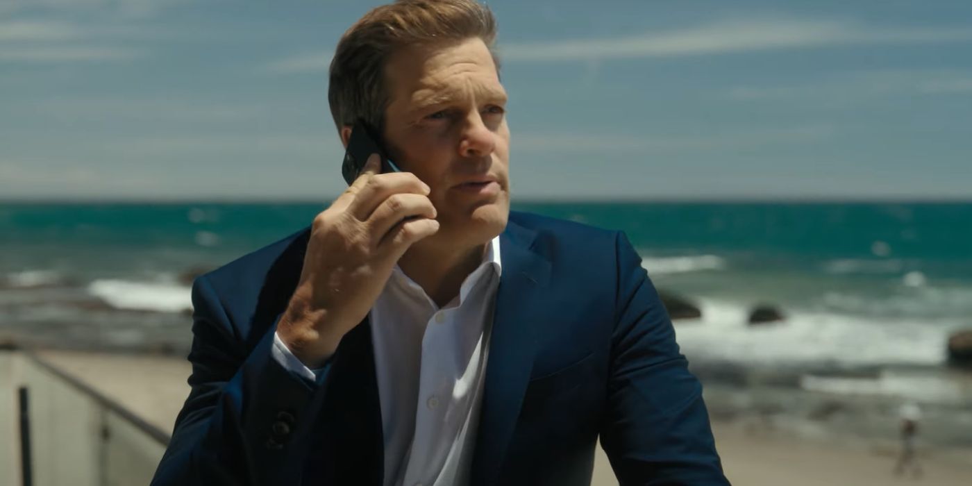 Geoff Stults on his phone at the beach as Jake in The Last Thing He Told Me