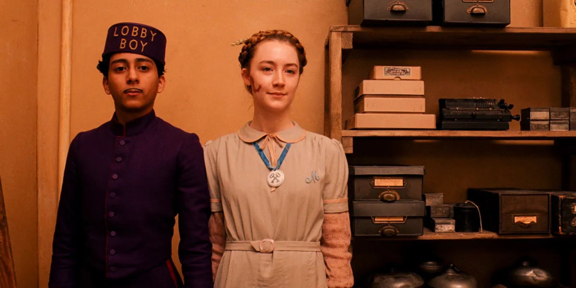 Tony Revolori and Saoirse Ronan as Zero and Agatha holding hands in The Grand Budapest Hotel