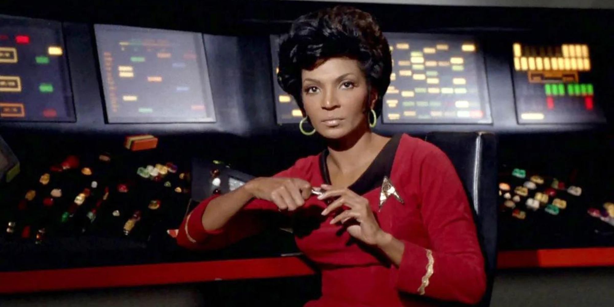 Uhura sits in front of Enterprise communications control panel