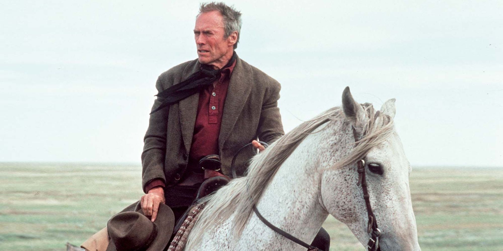 Clint Eastwood como Will Manny sobre un caballo blanco en Unforgiven