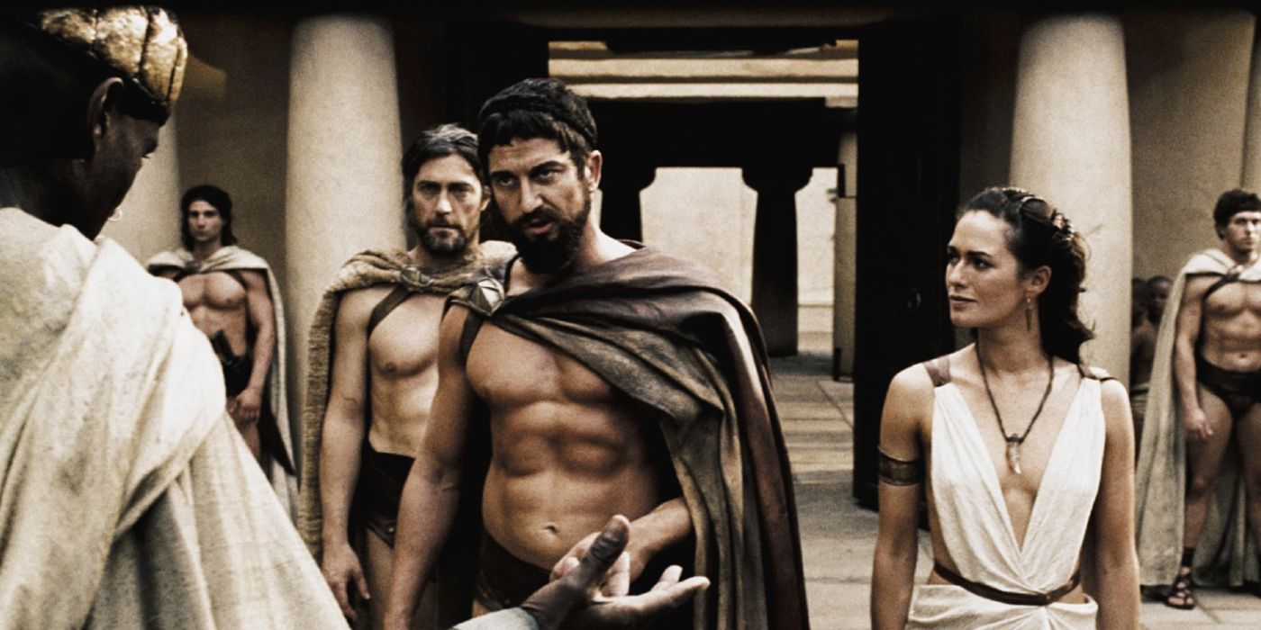 A group of people in ancient Spartan clothing gather around for a conversation