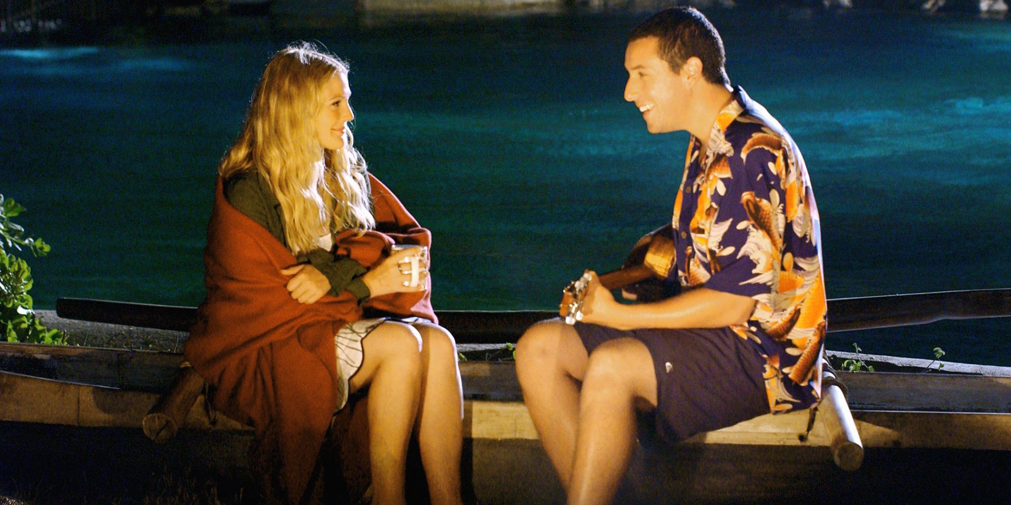 Drew Barrymore and Adam Sandler as Lucy and Henry sitting by a beach bonfire in 50 First Dates’ (2004) 