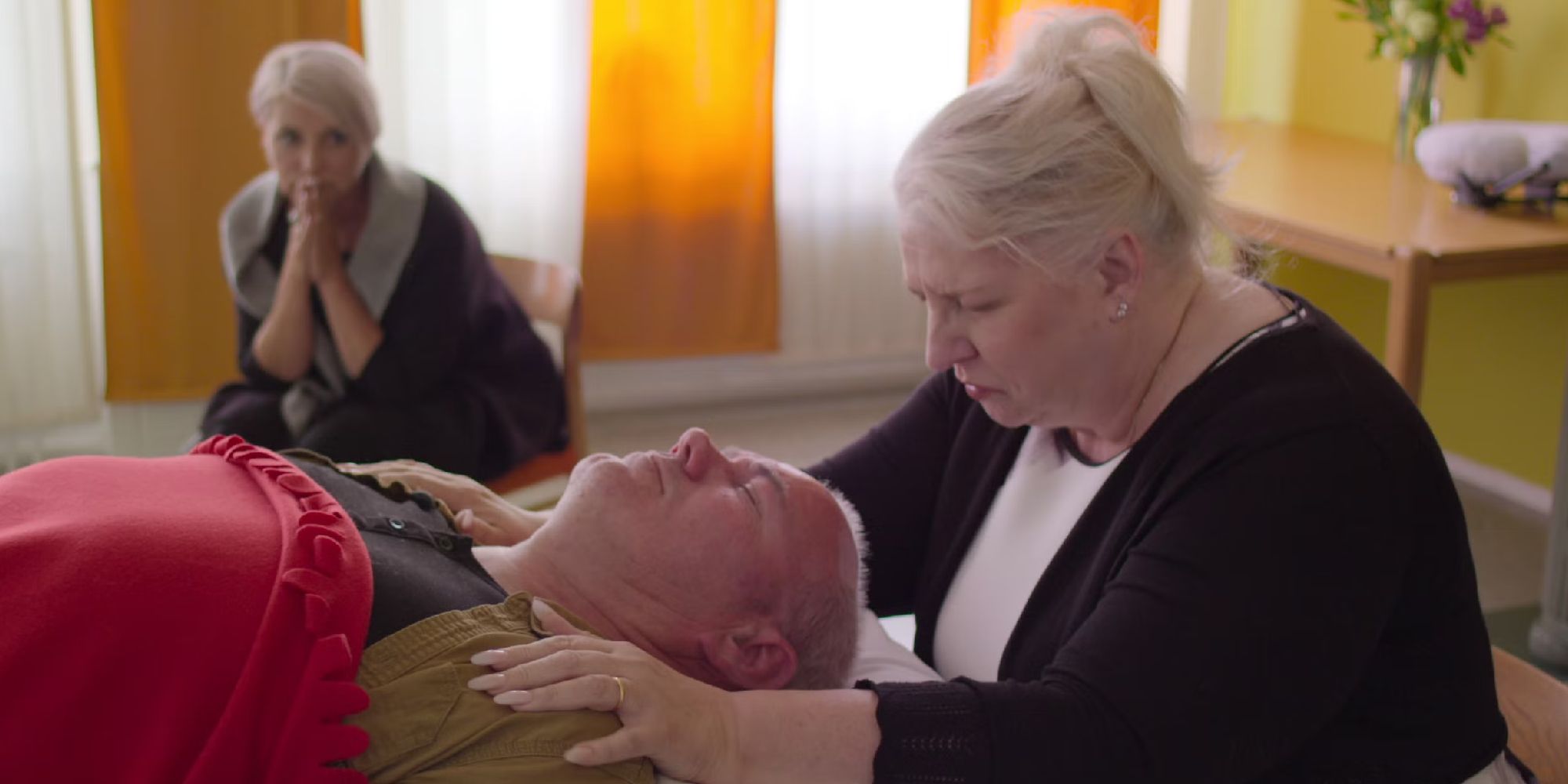 A man being spiritually treated by a woman in Surviving Death