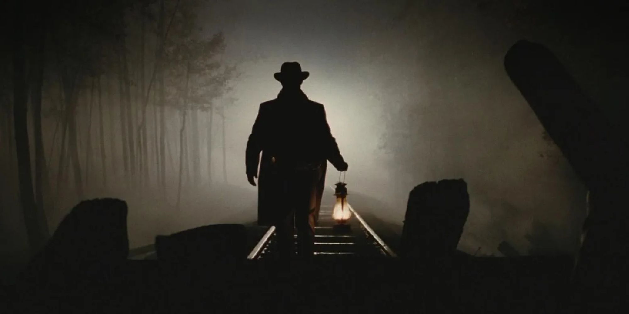 A man holding a lamp while walking in the middle of train tracks in The Assassination of Jesse James