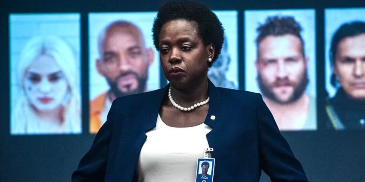 Viola Davis as Amanda Waller standing in front of photos of the Suicide Squad.