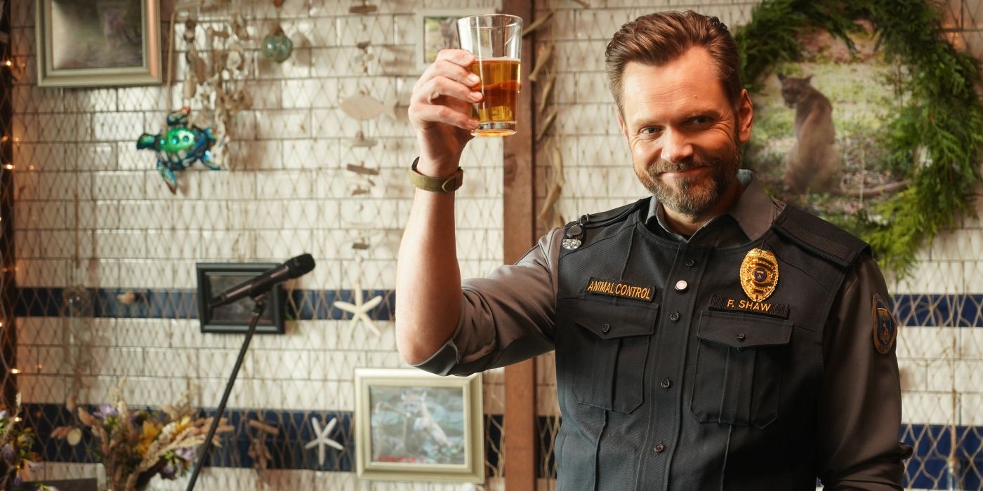 Joel McHale as Frank Shaw holding a glass up in a toast in Animal Control Season 1, Episode 12
