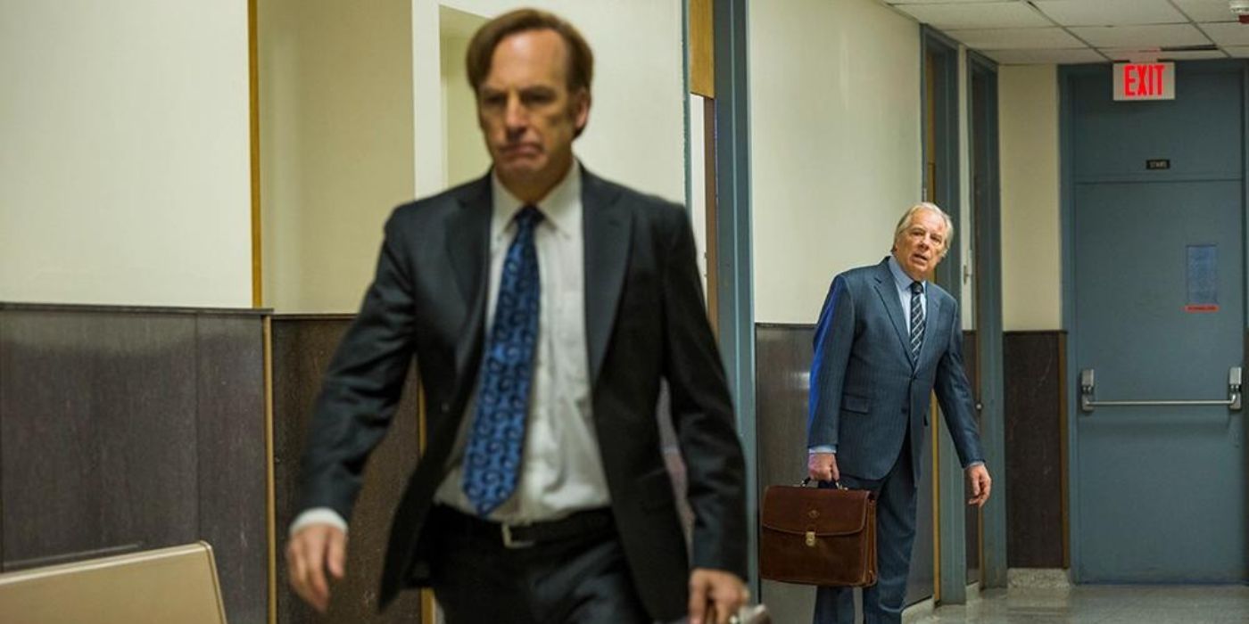 Chuck (Michael Mckean) wearing a suit and carrying a briefcase, looking at Jimmy (Bob Odenkirk) angrily walking away in Better Call Saul