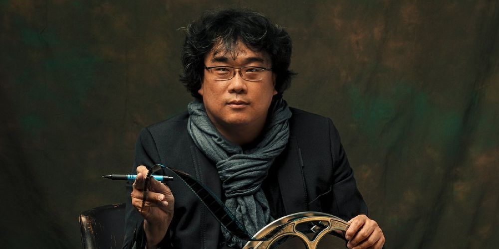 Bong Joon-ho sitting with a film reel and a pen