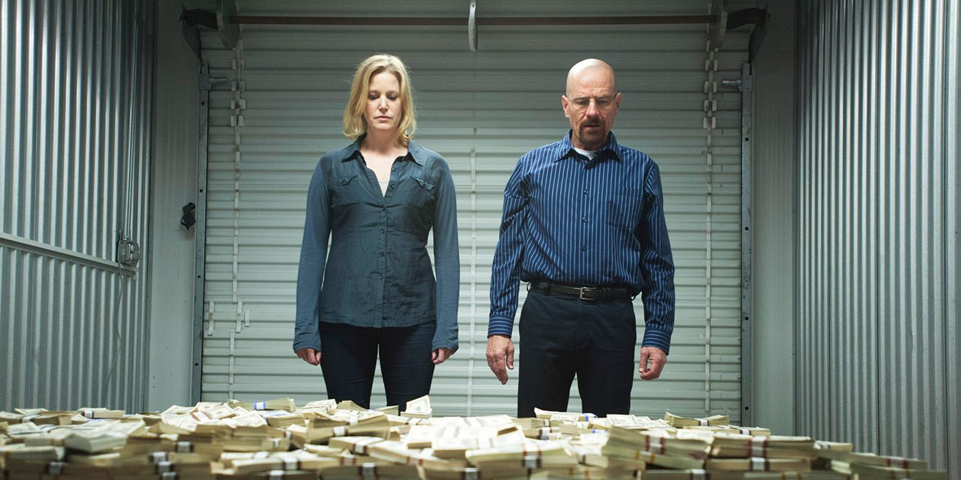 Skyler and Walter from Breaking Bad standing in a storage unit looking at piles of money.