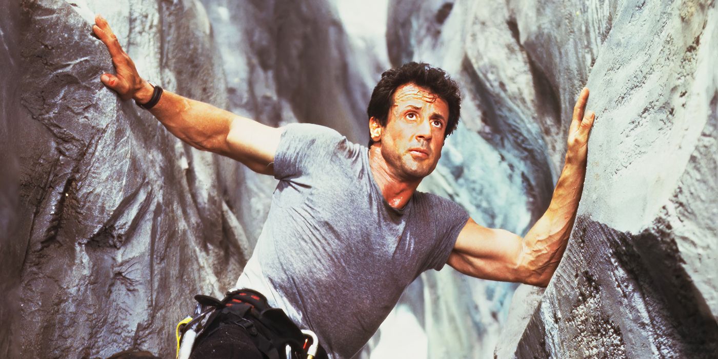 Sylvester Stallone steadies himself precariously in between two cliffsides in Cliffhanger.