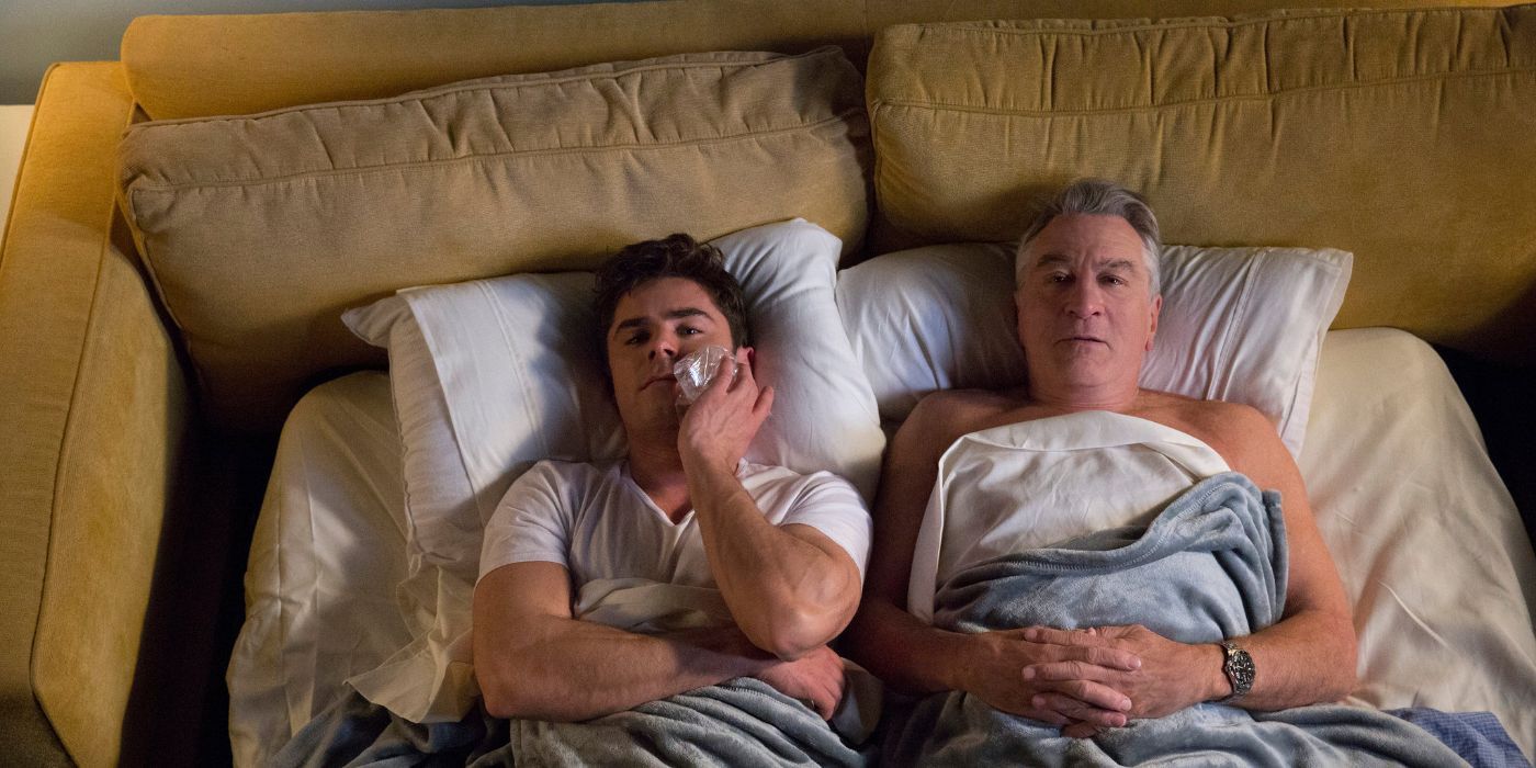 Zac Efron and Robert De Niro lie in a bed in Dirty Grandpa.