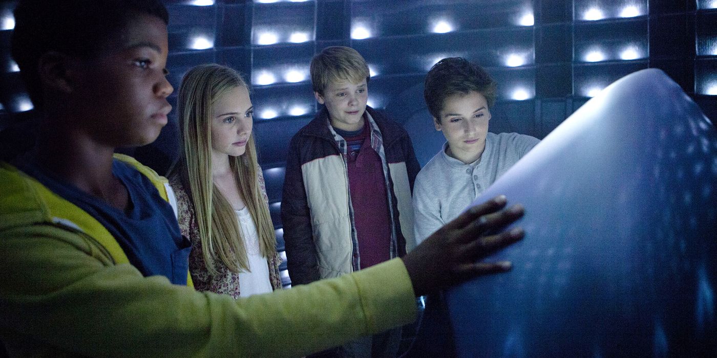 A still from the film 'Earth to Echo', featuring the main cast of children inside of an alien spaceship in wonder of a futuristic control panel.