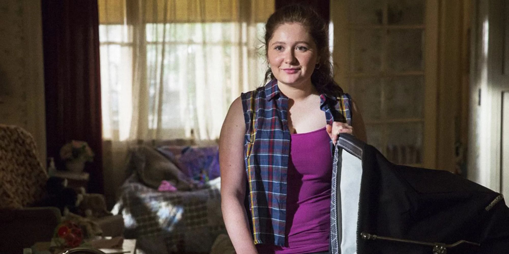 Emma Kenney as Debbie in 'Shameless' stands in front of an open suitcase