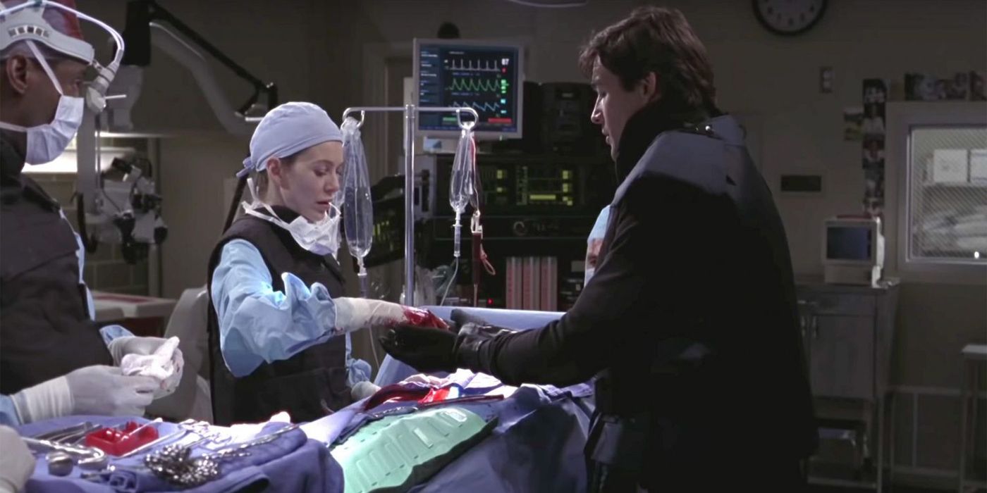 A doctor and a man in a bomb protection suit work over a patient in surgery on Grey's Anatomy.