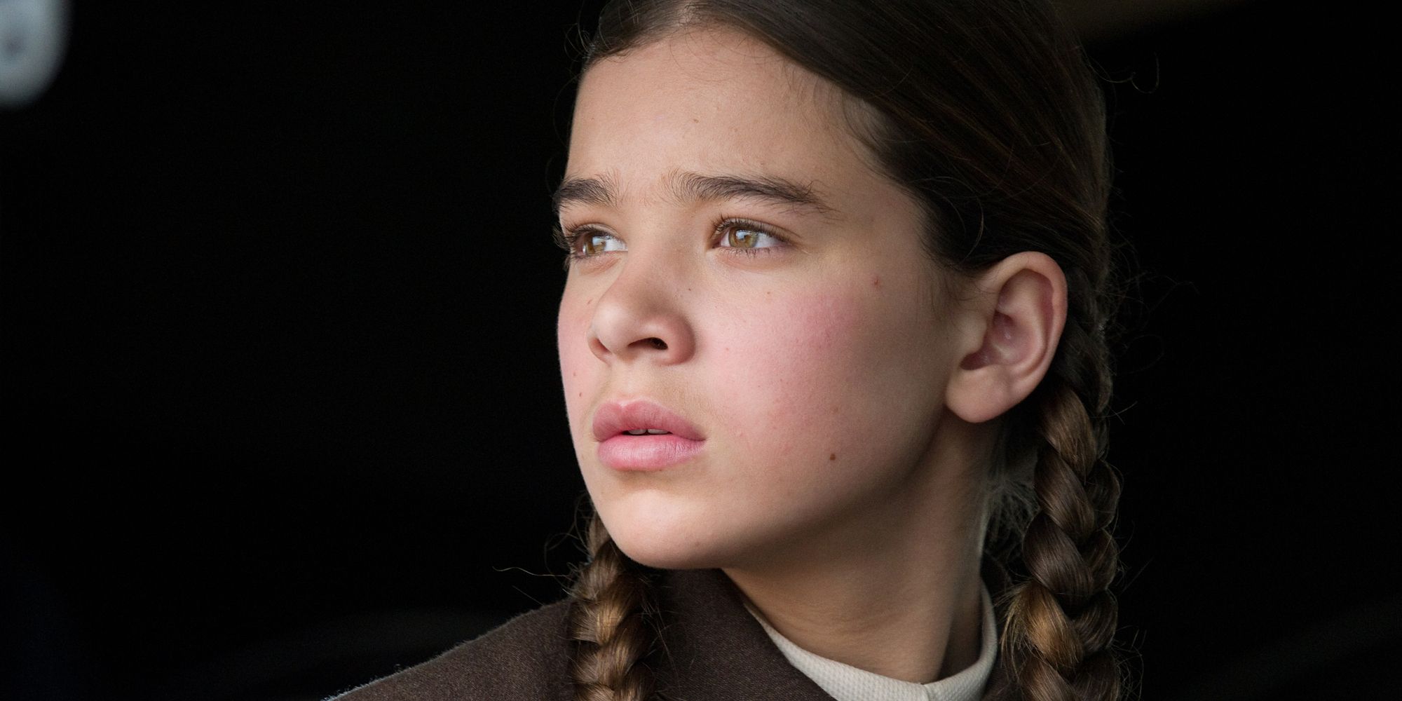 Close up of Hailee Steinfeld as Mattie, looking into the distance in 'True Grit'