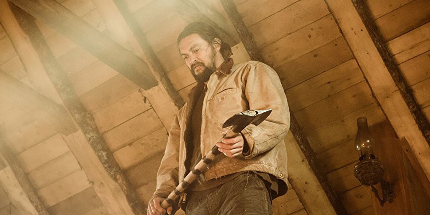 A photo shot from down low of Jason Momoa holding an ax in a scene from Braven.