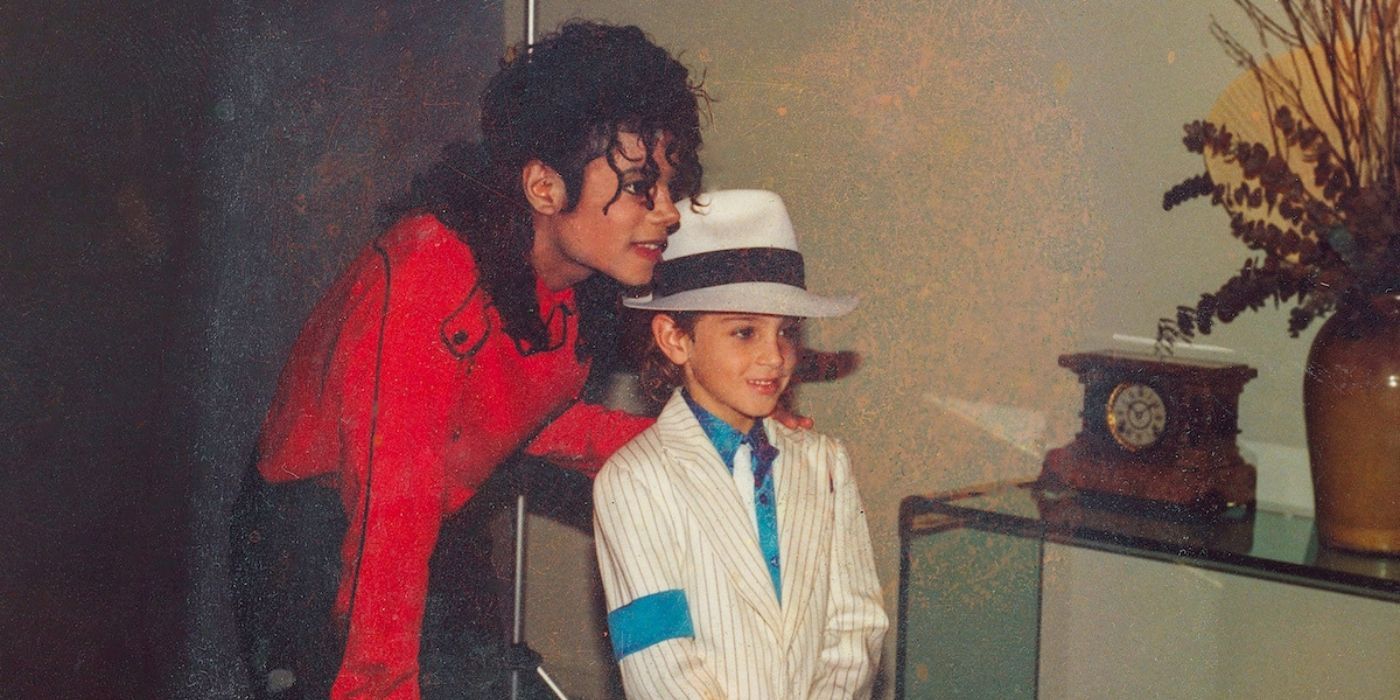 Michael Jackson smiling with his hand on a young boy's shoulder as they pose for a picture in the Leaving Neverland documentary