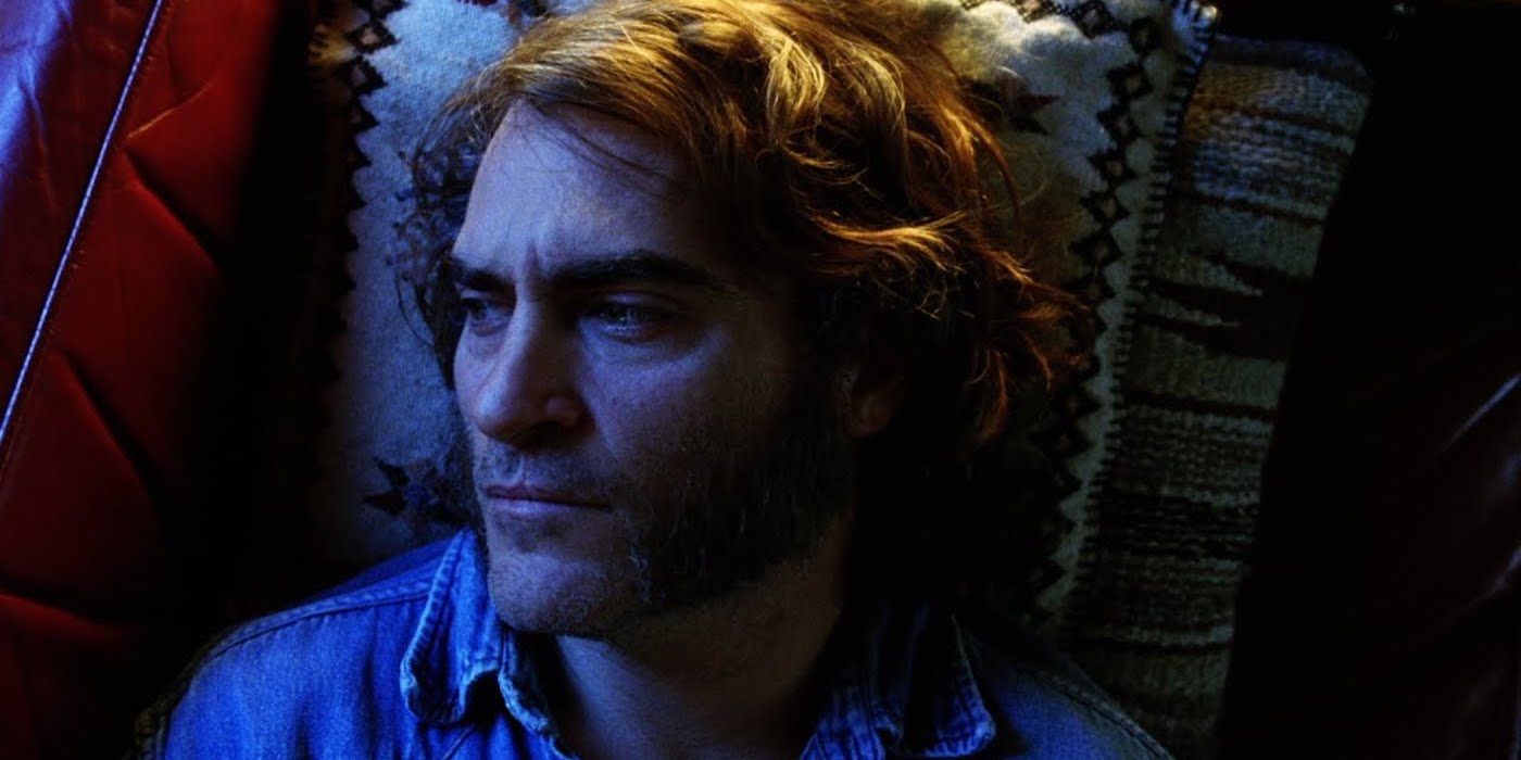Joaquin Phoenix as Doc Sportello lying on his couch against a blue light