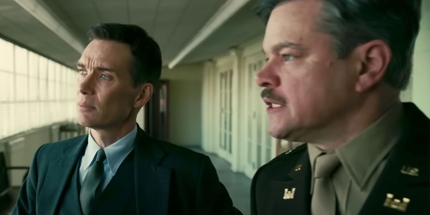 Cillian Murphy as J. Robert Oppenheimer and Matt Damon as General Groves standing in a hallway in Oppenheimer