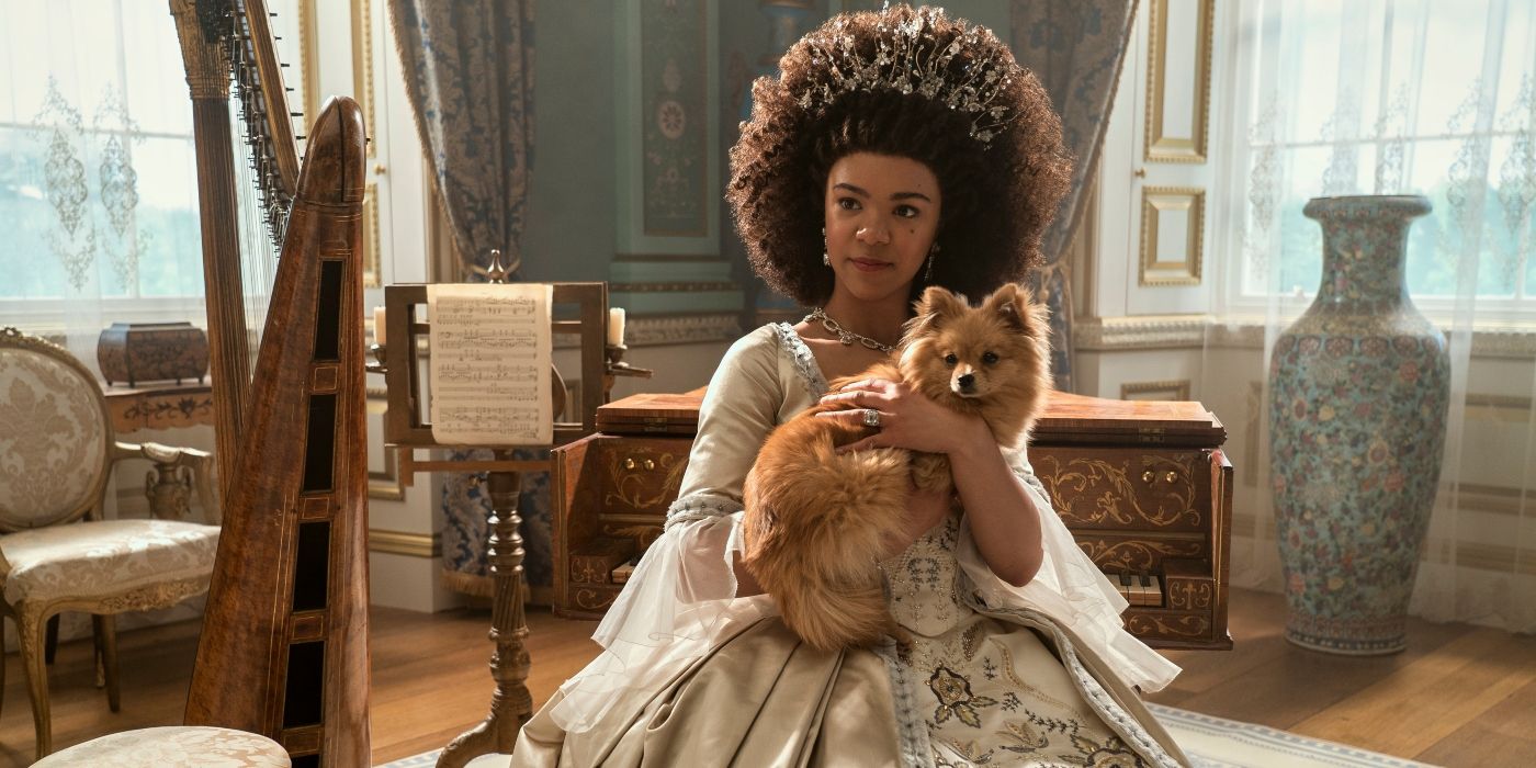 India Amarteifio as Queen Charlotte sitting and holding a Pomeranian puppy in Queen Charlotte