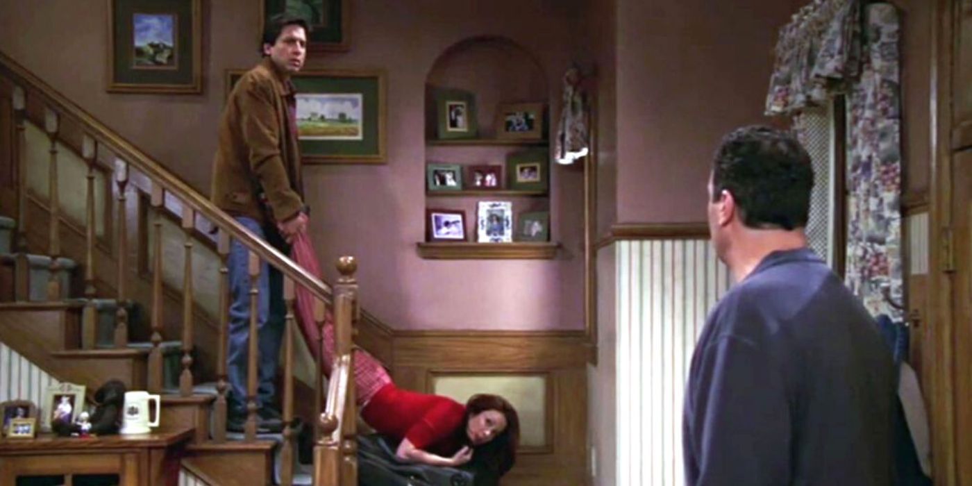 Ray Romano holding Patricia Heaton by her ankles on the stairs as Brad Garrett looks at them in Everybody Loves Raymond
