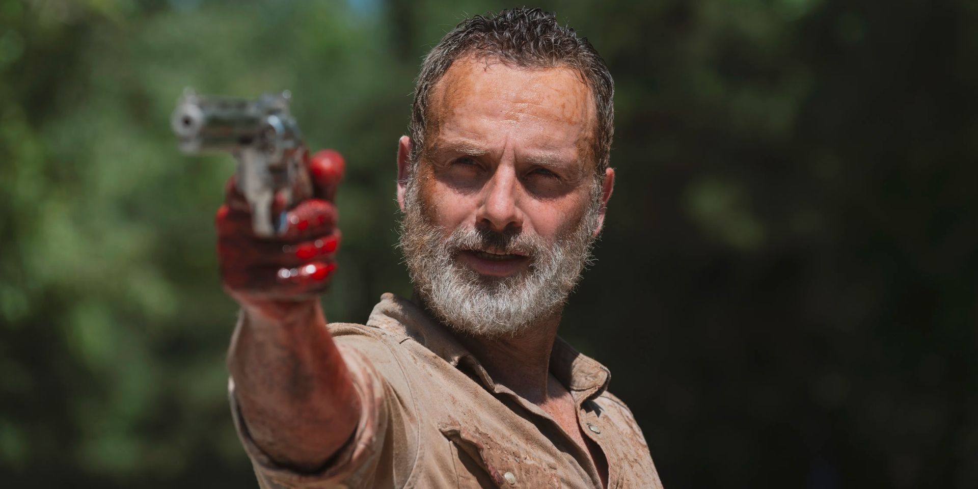 With a bloodied hand, an aged Rick Grimes aims down the sights of his gun.