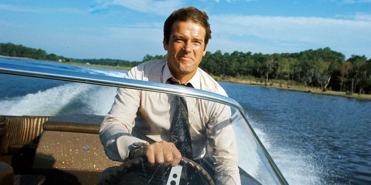 Roger Moore pilots a boat as James Bond in 