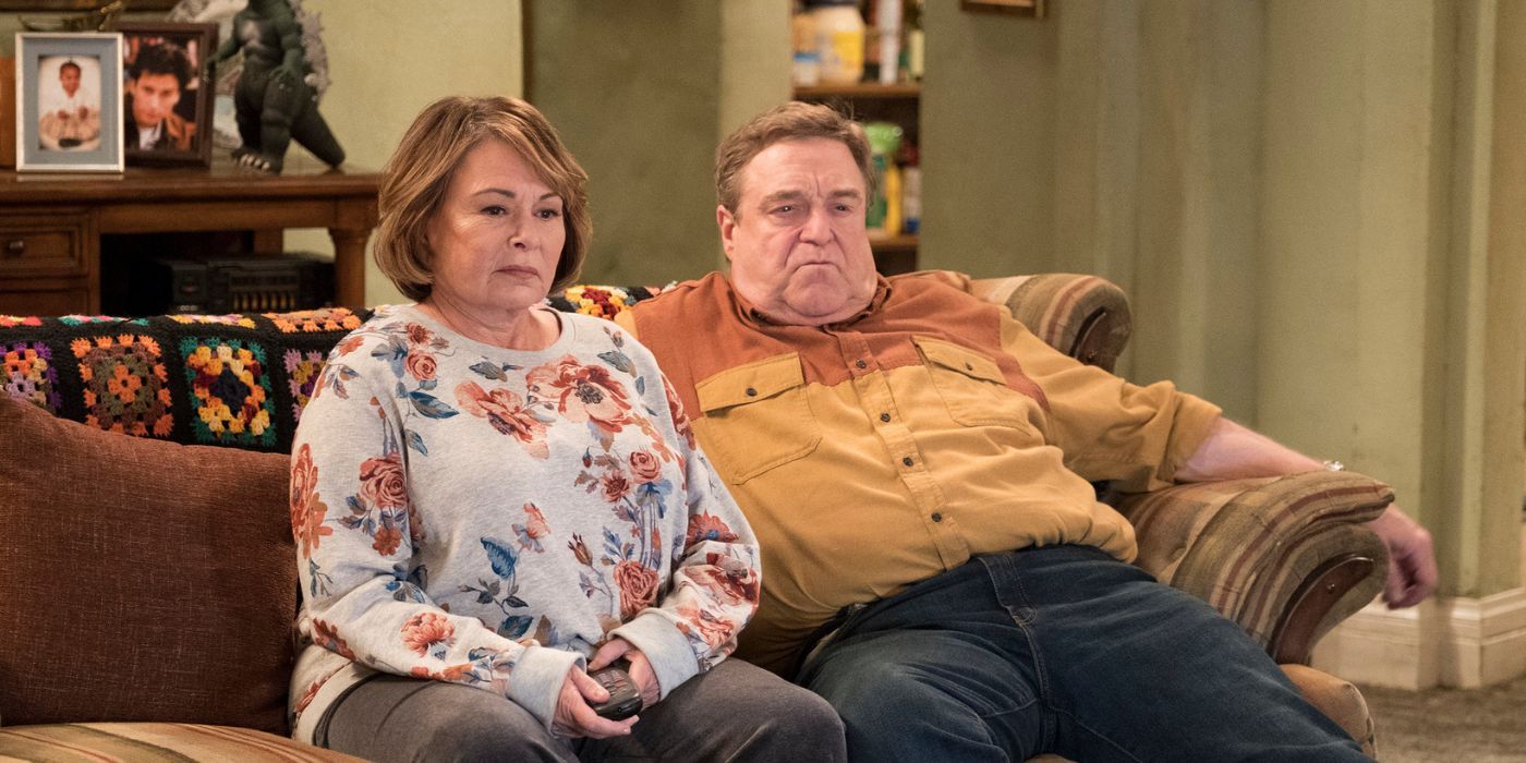 Roseanne Barr as Roseanne Conner and John Goodman as Dan Conner sitting on the couch in the Roseanne reboot