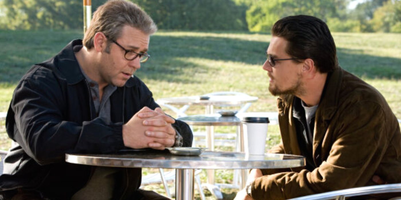 Russell Crowe sitting across a table from Leonardo DiCaprio in Body of Lies