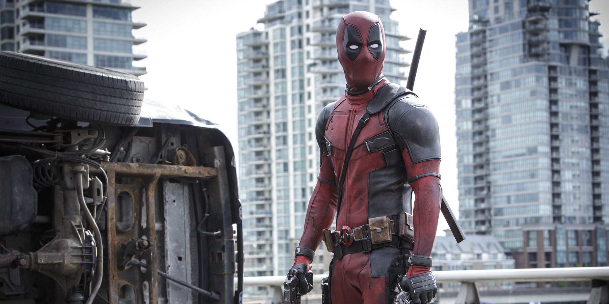 Ryan Reynolds as Deadpool standing in the middle of a collapsed bridge in Deadpool.