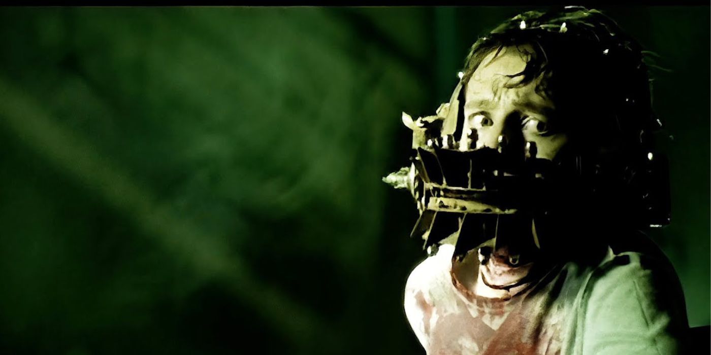 David (Leigh Whannell) in a bloody white t-shirt with a metal device locked on his face in Saw, the short film