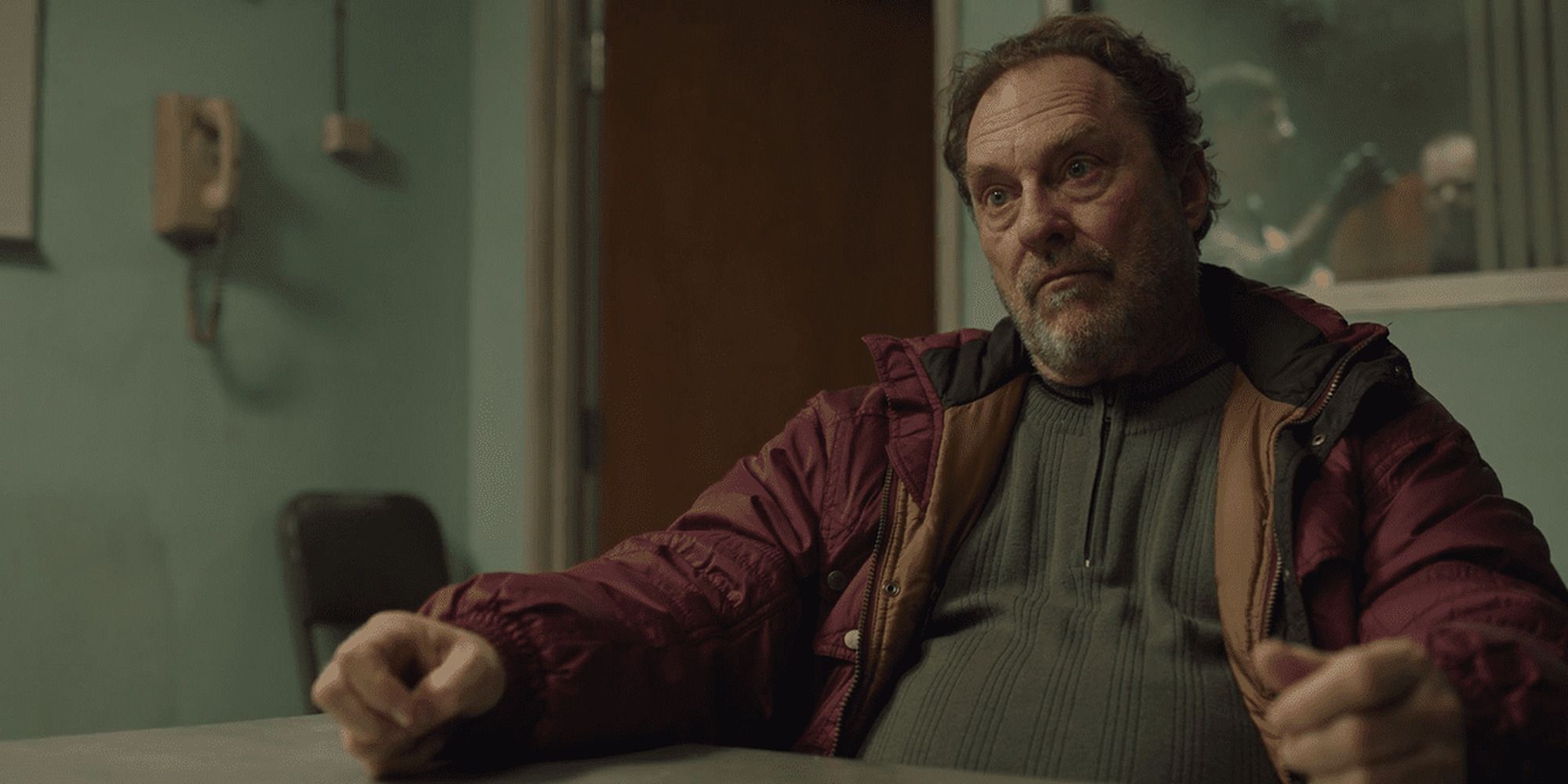 Stephen Root dans le rôle de Fuches dans 'Barry' assis dans la salle d'interrogatoire d'un poste de police