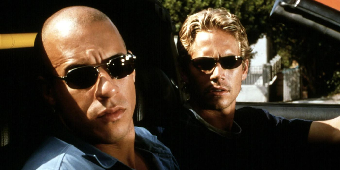 Vin Diesel and Paul Walker as Dom and Brian looking to their left from inside a car in the film The Fast and the Furious