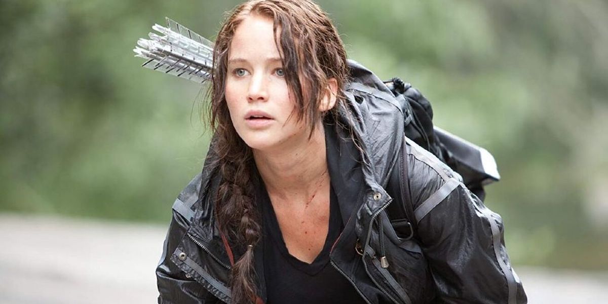 Jennifer Lawrence as Katniss Everdeen croutching and looking ahead attentively in The Hunger Games (2012)