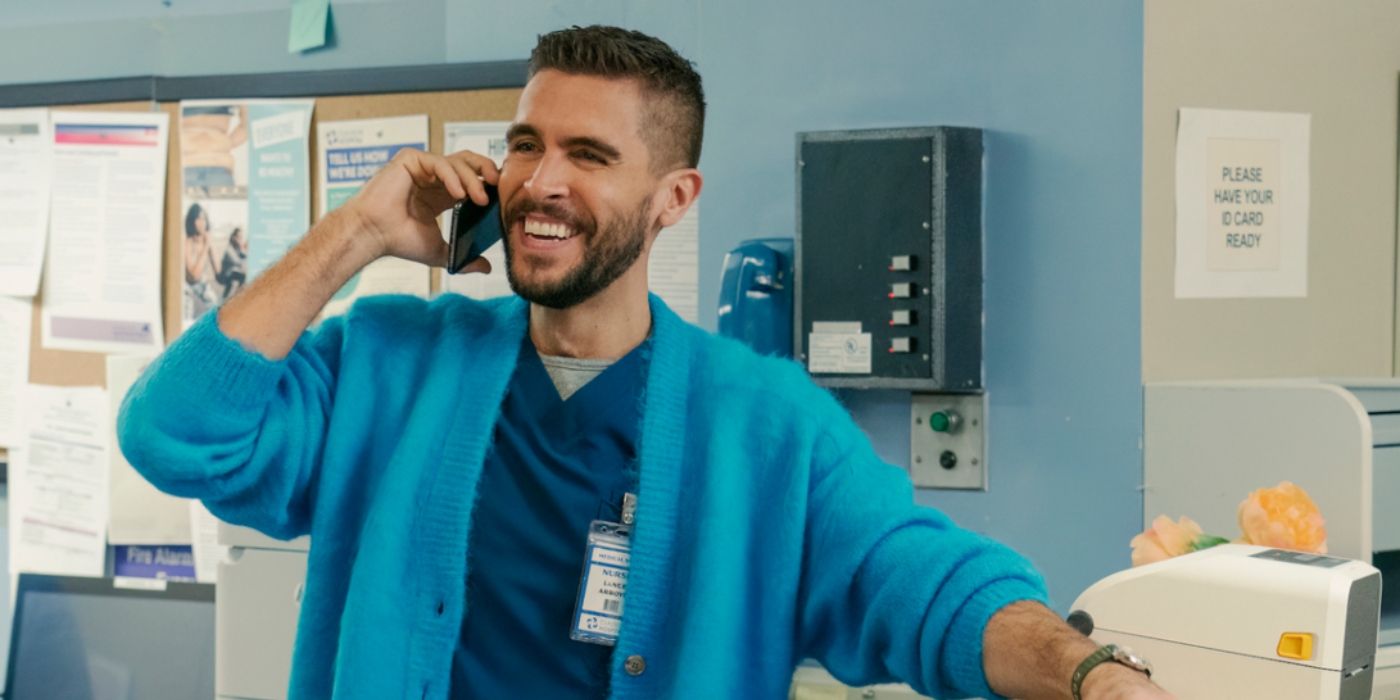 Josh Segarra as Lance Arroyo standing at a nurses station talking on the phone in The Other Two. 