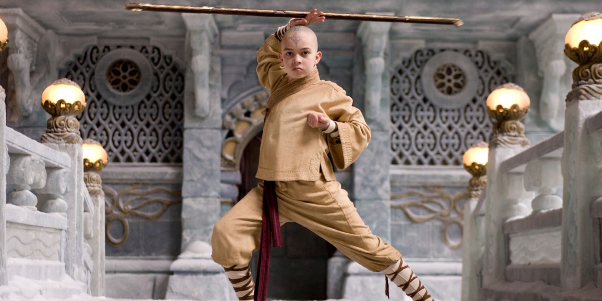 Aang stands with his bo staff above his head, poised for battle