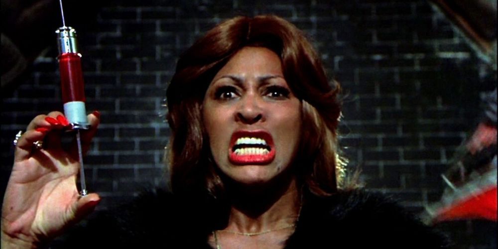 Tina Turner as the Acid Queen holding up a syringe in Tommy